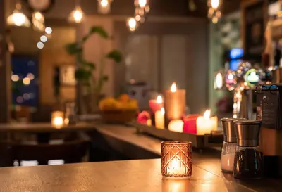 a bar with candles on a counter with a table at Hotel Villa Flora in Hillegom