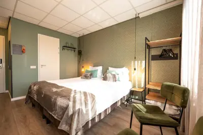 a bedroom with a large bed and a green wall at Hotel Villa Flora in Hillegom