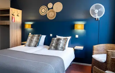 a hotel room with a bed and a blue wall at Hotel Villa Flora in Hillegom