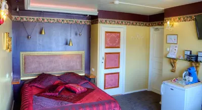 a bedroom with a bed with a red blanket at Pension & Spa de Watertoren in Zandvoort