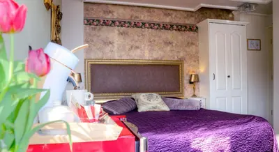a bedroom with a bed with a purple bedspread at Pension & Spa de Watertoren in Zandvoort