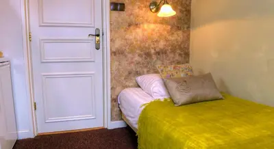 a bedroom with a bed and a door with a pillow at Pension & Spa de Watertoren in Zandvoort