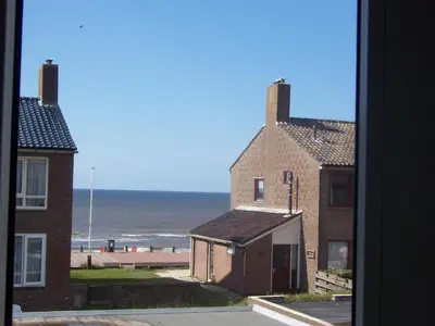 a view of the beach from a window of a building at Pension & Spa de Watertoren in Zandvoort