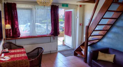 a room with a staircase and a table and a window at Pension & Spa de Watertoren in Zandvoort