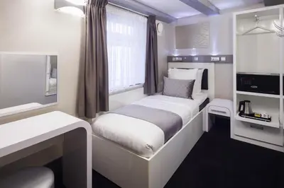 a small room with a bed and a window at Hotel CC in Amsterdam