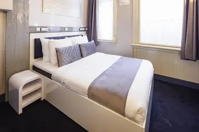a bedroom with a large bed with white sheets and pillows at Hotel CC in Amsterdam