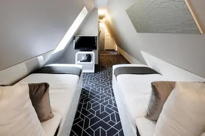 a hotel room with two beds and a tv at Hotel CC in Amsterdam