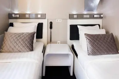 two beds in a small room with white pillows at Hotel CC in Amsterdam