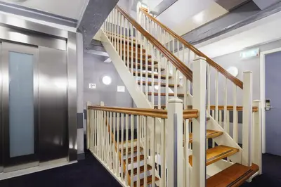 a wooden staircase in a room with a door at Hotel CC in Amsterdam