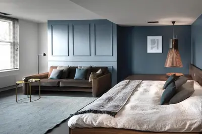 a living room with a bed and a couch at COMMUNE suites in Amsterdam