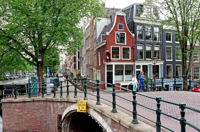 a bridge over a canal in a city with buildings at COMMUNE suites in Amsterdam