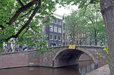 a bridge over a river with bikes on a building at COMMUNE suites in Amsterdam