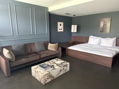 a bedroom with a bed and a couch and a table at COMMUNE suites in Amsterdam