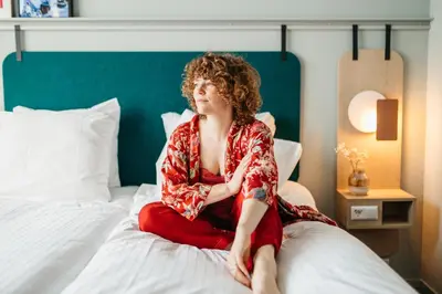 a woman sitting on top of a bed at Hotel Casa Amsterdam in Amsterdam
