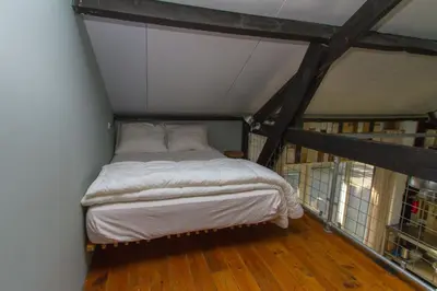 a bed in the corner of a room at Paardenstal, Private House with wifi and free parking for 1 car in Weesp