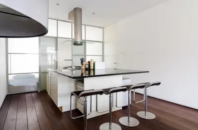 a kitchen with a black counter and some stools at Marnix360apartments Modern in Amsterdam