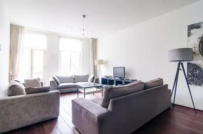 a living room with two couches and a table at Marnix360apartments Modern in Amsterdam