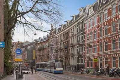 a bus driving down a city street with buildings at Marnix360apartments Modern in Amsterdam