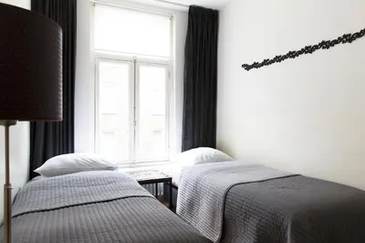 two beds in a room with a window at Marnix360apartments Design in Amsterdam