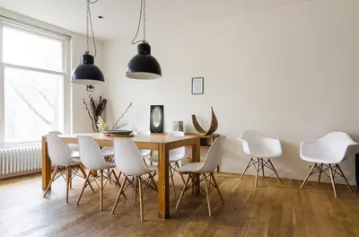 a dining room with a table and white chairs at Marnix360apartments Design in Amsterdam