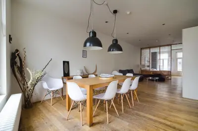 a dining room and living room with a wooden table and white chairs at Marnix360apartments Design in Amsterdam