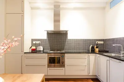 a kitchen with white cabinets and a stove top oven at Marnix360apartments Classic in Amsterdam