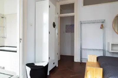 a bedroom with a bed and a chair and a window at Marnix360apartments Classic in Amsterdam