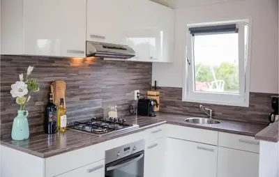 a kitchen with white cabinets and a counter top at Awesome Home In Breukelen in Breukelen
