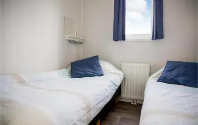 two twin beds in a room with a window at Cozy Home In Breukelen With Wifi in Breukelen