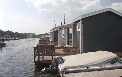 a boat parked on a dock next to a house at Cozy Home In Breukelen With Wifi in Breukelen