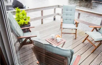 a balcony with two chairs and a table with a candle at Cozy Home In Breukelen With Wifi in Breukelen