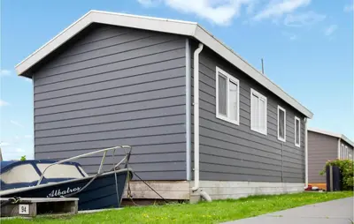 a house with a boat parked in front of it at Cozy Home In Breukelen With Wifi in Breukelen