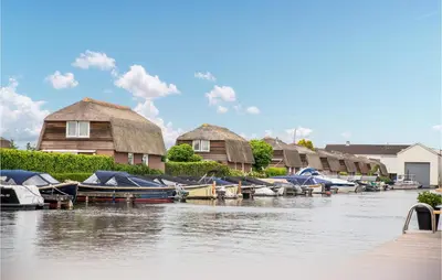 a group of boats docked next to houses on a river at Cozy Home In Breukelen With Wifi in Breukelen