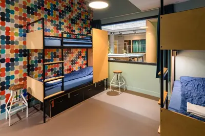 a room with bunk beds and a wall of colorful tiles at Stayokay Hostel Utrecht Centrum in Utrecht