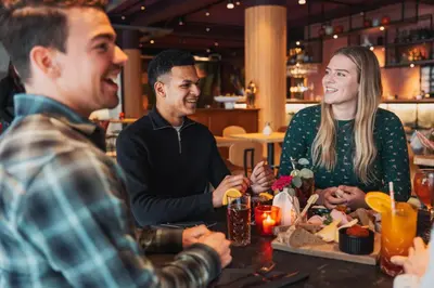 a group of people sitting around a table in a restaurant at Stayokay Hostel Utrecht Centrum in Utrecht