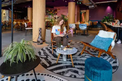 a woman sitting in a chair in a room at Stayokay Hostel Utrecht Centrum in Utrecht