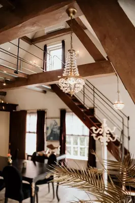 a dining room with a table and a chandelier at Villa Beukenhof in Oegstgeest