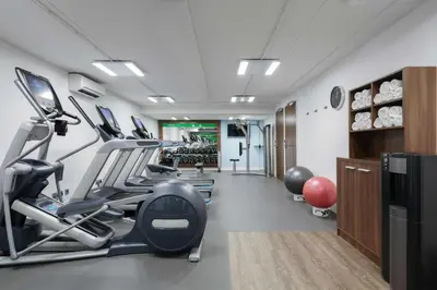 a gym with treadmills and ellipticals in a room at Hampton by Hilton Amsterdam Centre East in Amsterdam
