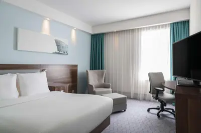 a hotel room with a bed and a desk and a tv at Hampton by Hilton Amsterdam Centre East in Amsterdam