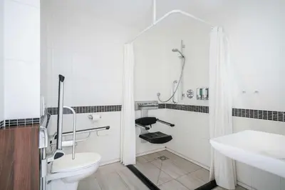 a bathroom with a shower and a toilet and a sink at Hampton by Hilton Amsterdam Centre East in Amsterdam