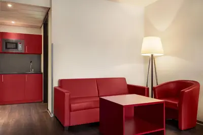 a living room with a red couch and a table at Amedia Amsterdam Airport Schiphol, Trademark Collection by Wyndham in Schiphol