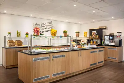 a restaurant with a buffet of food on display at Amedia Amsterdam Airport Schiphol, Trademark Collection by Wyndham in Schiphol