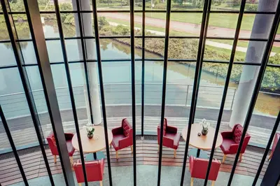 a room with a table and chairs and a pool at Amedia Amsterdam Airport Schiphol, Trademark Collection by Wyndham in Schiphol