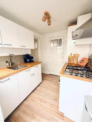 a kitchen with white cabinets and a counter top at Beach House Sea-Esta in Egmond aan Zee