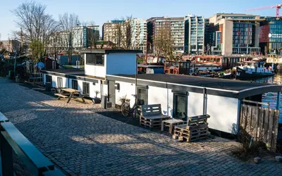 a small building on a street next to a body of water at Houseboat-Amsterdam in Amsterdam