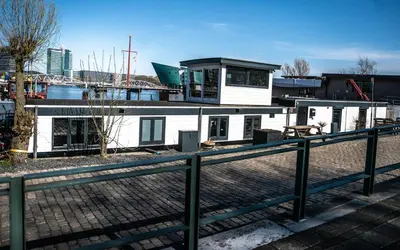 a white house with a fence in front of it at Houseboat-Amsterdam in Amsterdam