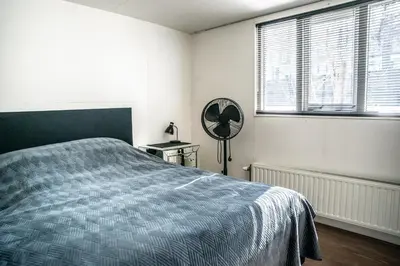 a bedroom with a bed and a mirror and windows at Houseboat-Amsterdam in Amsterdam