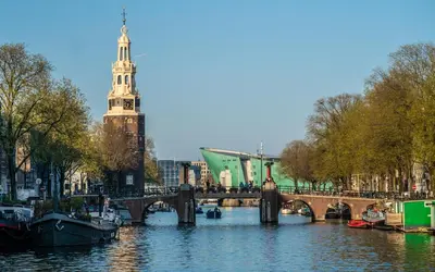 a river with a bridge and a clock tower at Houseboat-Amsterdam in Amsterdam