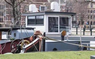a boat docked at a dock in a city at Houseboat-Amsterdam in Amsterdam