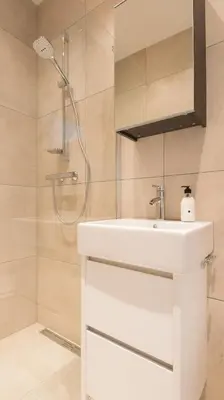 a bathroom with a white sink and a shower at Happy Day´s in Amsterdam